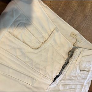 White Maje jeans with quilted denim design on sides of legs and belt buckle area